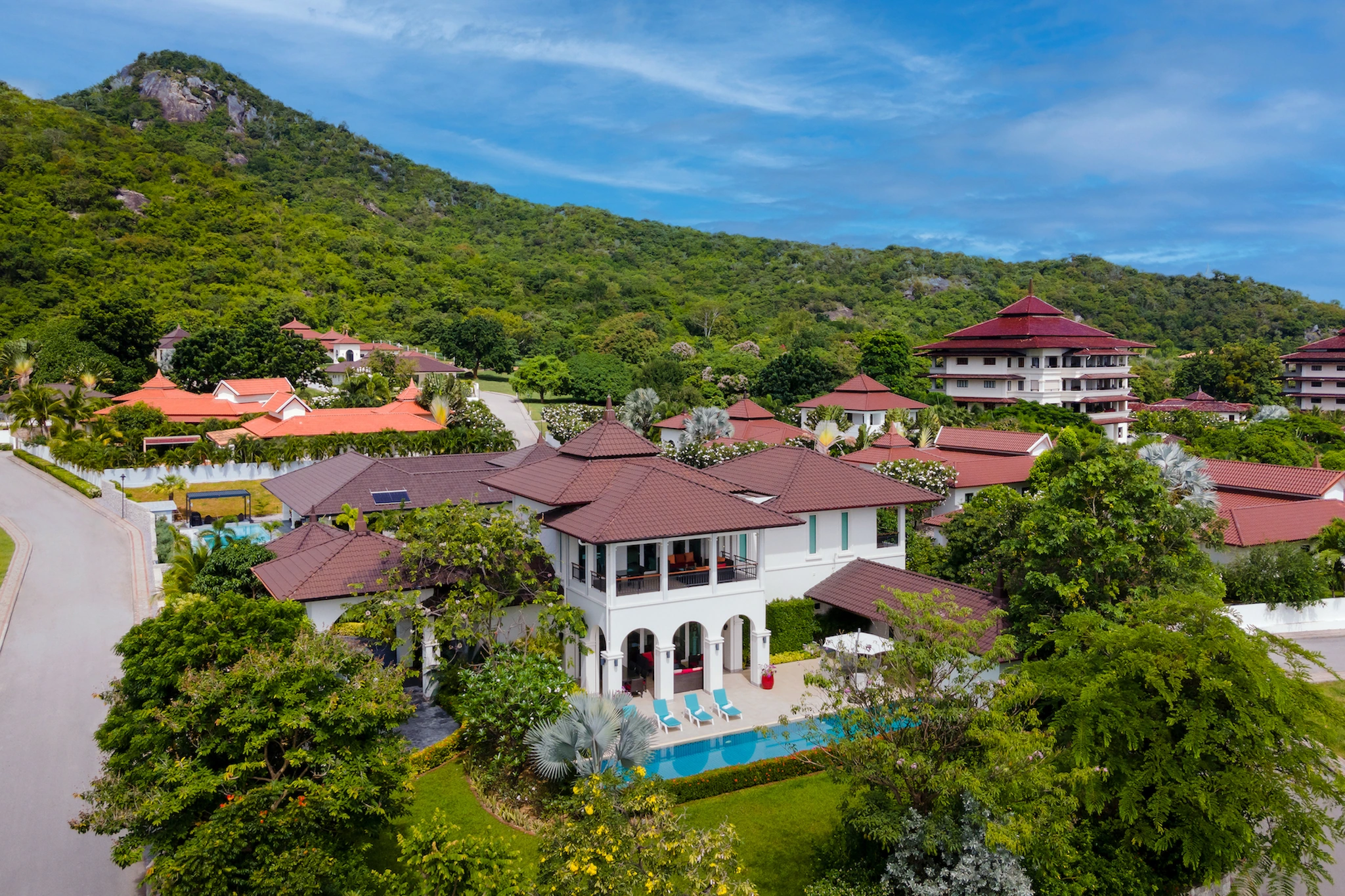Aerial view of Villa 18 and its pool with green Hua Hin hills behind the estate