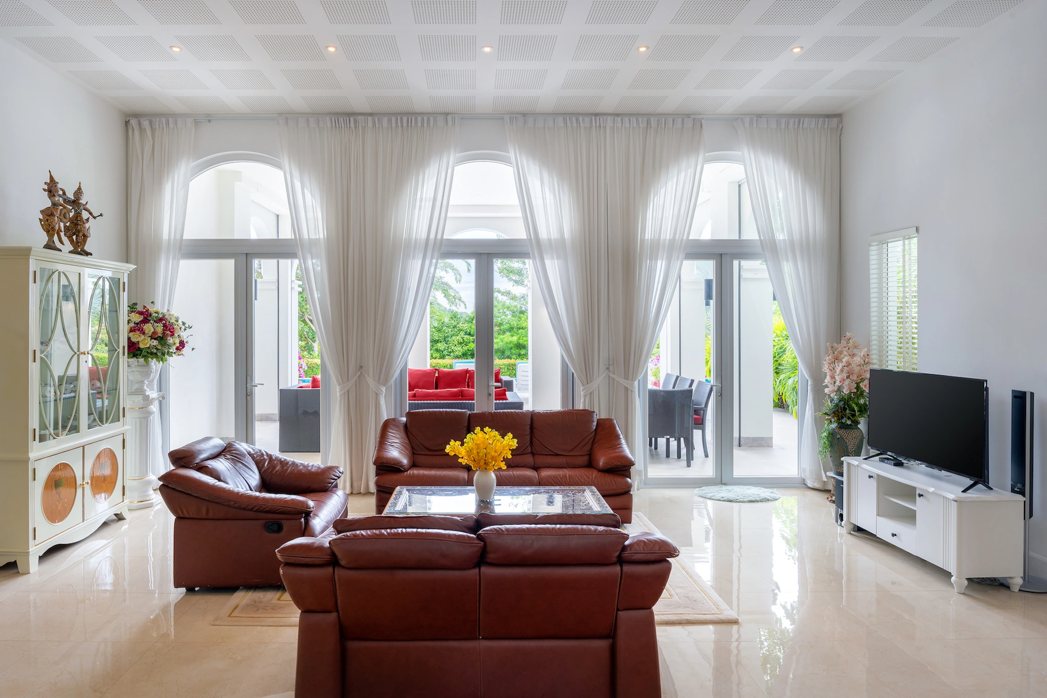 Expansive living room with arched doors and coffered ceilings