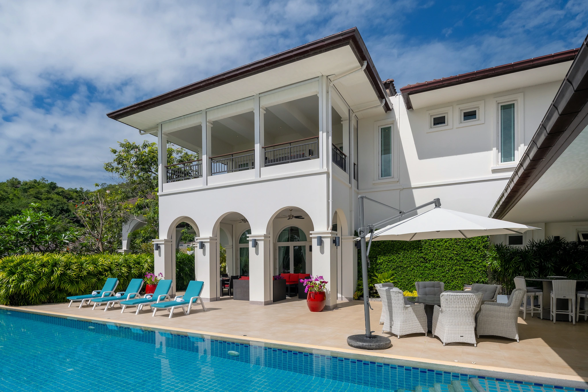 The white arched facade of Villa 18 overlooking its blue swimming pool