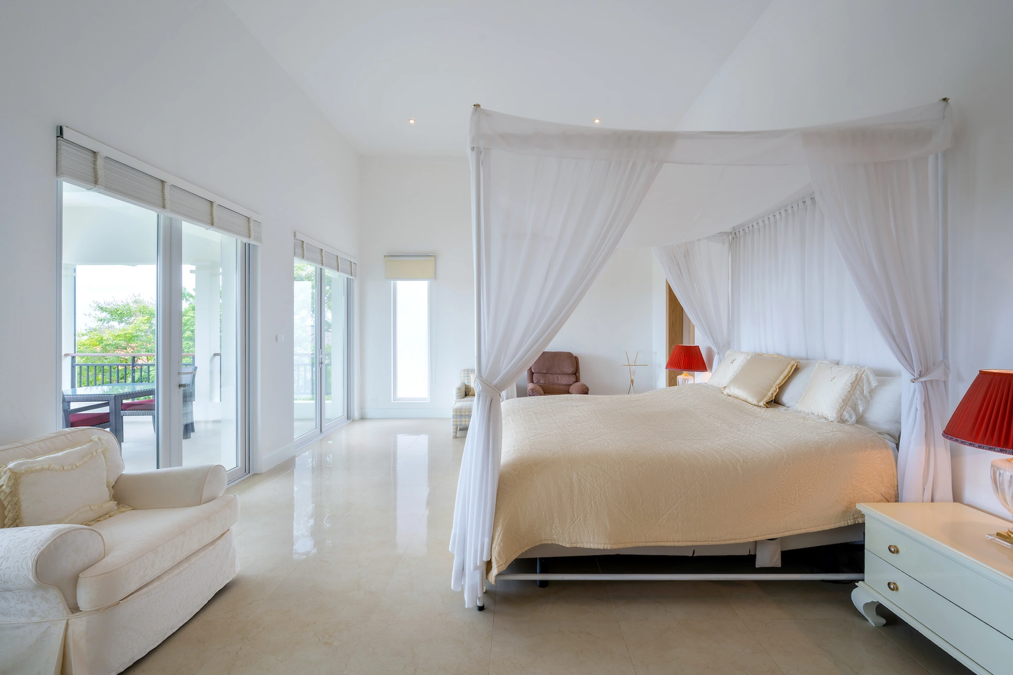 Primary bedroom with a four-poster bed and terrace doors